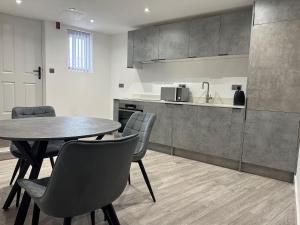 uma cozinha e sala de jantar com mesa e cadeiras em Apartment In Luton Town Centre em Luton
