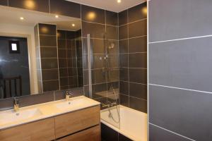 a bathroom with a shower and a sink and a tub at Trois Vallées Appartements VTI in Val Thorens