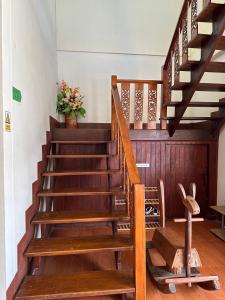 una escalera de madera en una casa con una planta en กาลครั้งหนึ่ง ณ เชียงคาน (Once Upon A time) en Chiang Khan