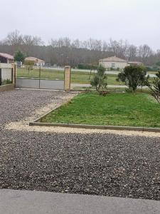 un parco con recinto e prato di MAISON DU BONHEUR a Lesparre-Médoc