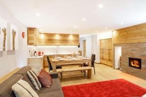 a living room with a couch and a table with a fireplace at HelloCHALET - Maison Rêve Blanc - Ski to door with Matterhorn view in Breuil-Cervinia