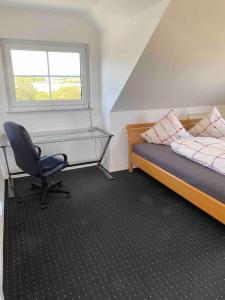 a bedroom with a desk and a bed and a chair at Mawo Lodge in Lohfelden