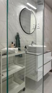 a white bathroom with a sink and a mirror at Linden Apartman 001 - Adults Only in Mosonmagyaróvár