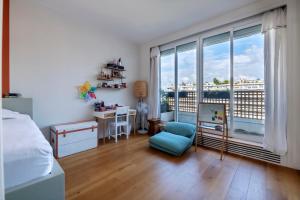 una camera con letto, scrivania e ampia finestra di Veeve - Eiffel Exuberance a Parigi