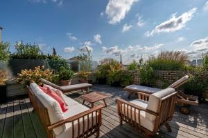 a patio with chairs and tables on a deck at Veeve - Eiffel Exuberance in Paris