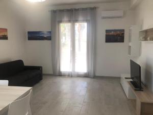 a living room with a couch and a large window at Finalmente in vacanza in Xitta