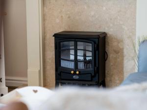 a black television sitting in a corner of a room at Hawthorn Cottage in Richmond