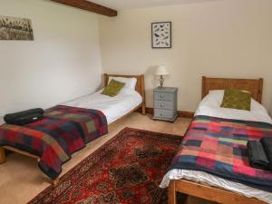 sypialnia z 2 łóżkami i dywanem w obiekcie Y Beudy Garndeifog w mieście Llanychaer