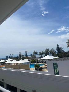 a view of a resort with a pool and umbrellas at The Entrance Superb Apartment The Entrance NSW with Ocean - Lake Views in The Entrance