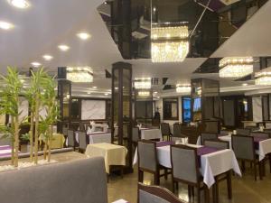 una sala da pranzo con tavoli, sedie e luci di alfin otel a Ankara