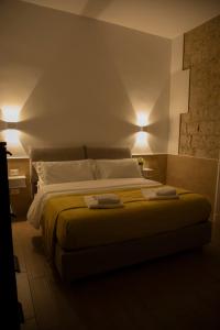 una camera da letto con un letto e due asciugamani di H22 Hotel a Napoli