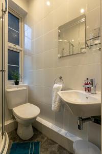a white bathroom with a toilet and a sink at Experience Vibrant Covent Garden - The Wanderlust by SmartStays in London