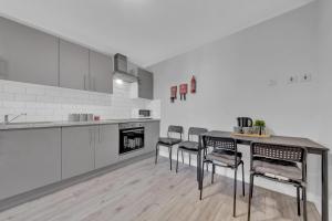 a kitchen with four chairs and a table in it at Lovely 1-Bed Studio in West Drayton in West Drayton