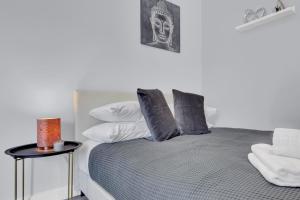 a bedroom with a bed with pillows and a side table at Lovely 1-Bed Studio in West Drayton in West Drayton