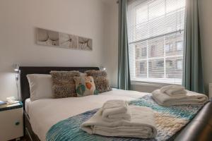 a bedroom with a bed with towels on it at Experience Vibrant Covent Garden - The Wanderlust by SmartStays in London