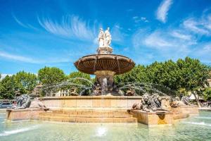 einen Brunnen in einem Park an einem sonnigen Tag in der Unterkunft Le Cardinale - Un Voyage en Provence - 2 chambres avec parking in Aix-en-Provence