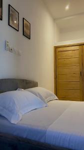 a bedroom with a bed and a wooden door at Home4u Fidji F2 in Cotonou
