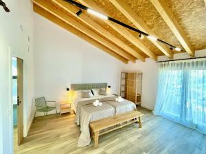 1 dormitorio con 1 cama y un banco en una habitación en El Ciprés de Valdeprados, en Valdeprados