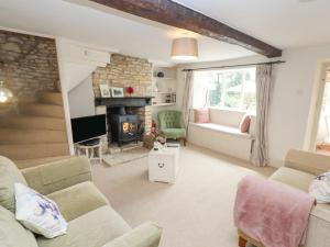 a living room with a couch and a fireplace at Grange Cottage in Woodchester