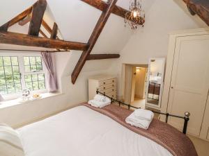 a bedroom with a large bed and a window at Grange Cottage in Woodchester