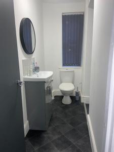 a bathroom with a toilet and a sink and a mirror at Rock Lane House by Serviced Living Liverpool in Rock Ferry