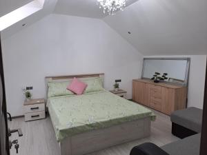 a bedroom with a bed with a pink pillow and a mirror at Mareto House in Turda