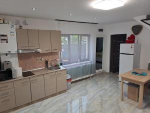 a kitchen with white cabinets and a sink and a table at Mareto House in Turda