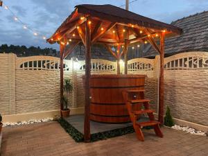 a wooden gazebo with a wooden chair on a patio at Mareto House in Turda