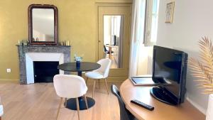 - un salon avec une télévision et une table avec des chaises dans l'établissement Appartement Bossoreil 110m2 - 3 chambres, à Angers
