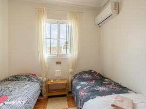 1 dormitorio con 2 camas y ventana en Stunning holiday home in Cabo Roig not far from the beach en Cabo Roig