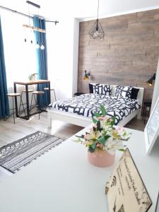 un dormitorio con una cama y una mesa en Central Park Studio Petrosani, en Petroşani