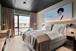 a bedroom with a large bed with a large screen at Hotell Jæren in Bryne