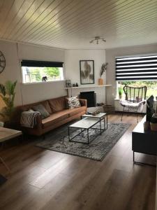 a living room with a couch and a table at Heerlijk huisje op de Veluwe in Ermelo