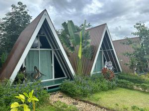 a small house with a triangular roof and windows at 99 Camp and Cafe in Khao Sok National Park