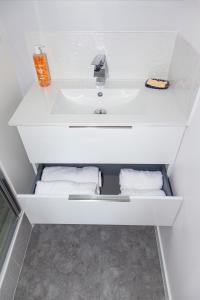 a white sink in a bathroom with towels at LA BATISSE l'arbre gris in Le Grand-Abergement