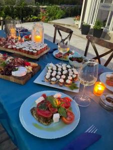 a blue table with plates of food and glasses of wine at Комплекс Радост in Ezerets