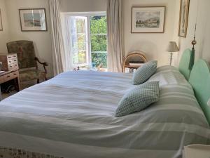 a large bed with two pillows on it in a bedroom at Garden Cottage B&b in Penton Mewsey