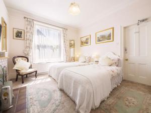 - une chambre blanche avec 2 lits et une fenêtre dans l'établissement Braemar Guest House, à Buxton