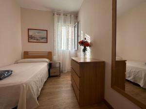 1 dormitorio con 2 camas y vestidor con espejo en Dos Torres Tenor Gayarre - Encanto con Balcón Interior, en Zaragoza