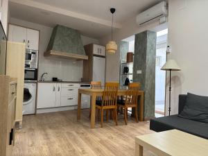 Una cocina y una sala de estar con mesa y sillas. en Dos Torres Tenor Gayarre - Encanto con Balcón Interior, en Zaragoza