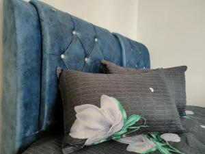 a blue couch with pillows and a flower on it at 2 Seaview Balcony@Danga Bay in Johor Bahru