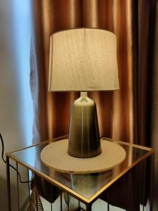 a lamp on a glass table with a lamp shade at 2 Seaview Balcony@Danga Bay in Johor Bahru