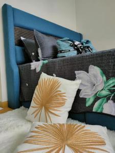 a pile of pillows on a bed with a blue headboard at 2 Seaview Balcony@Danga Bay in Johor Bahru