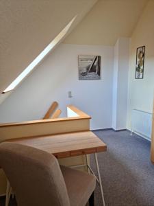 Cette chambre mansardée dispose d'une table en bois et d'un escalier. dans l'établissement Seeräuber, à Schönberger Strand