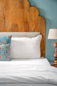 a bed with a wooden headboard and a white pillow at The Almond Tree in Jodhpur