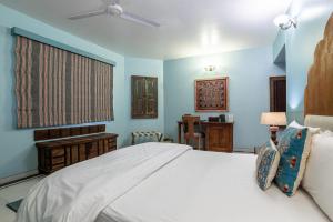 a bedroom with a white bed and blue walls at The Almond Tree in Jodhpur