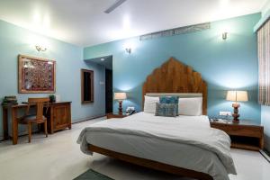 a bedroom with a large bed and a blue wall at The Almond Tree in Jodhpur