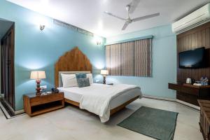 a bedroom with a large bed and a tv at The Almond Tree in Jodhpur