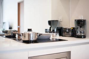 a kitchen with two pots and pans on a stove at Soho Suites KLCC in Kuala Lumpur