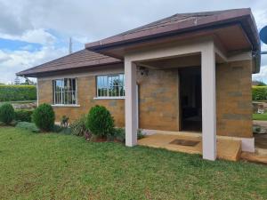 a small house with a wooden deck in the yard at Stay with Eve in Kitale